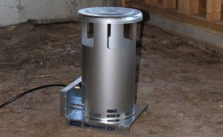 Metallic heater on a concrete floor with wooden walls in the background
