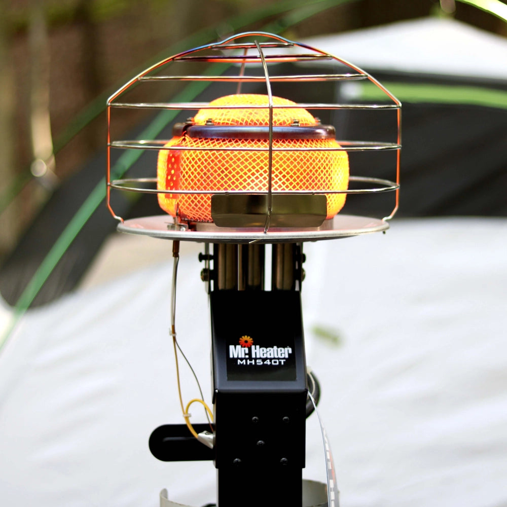 Portable heater with a cage on top, brand 'Mr. Heater' visible, outdoor setting.